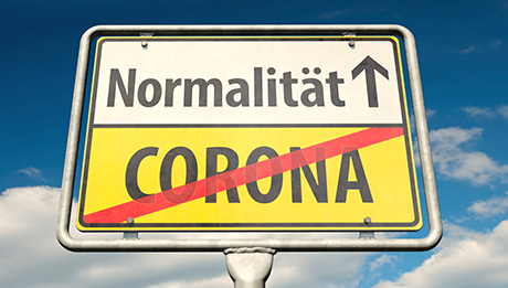 Wir freuen uns auf Ihre Teilnahme bei unseren Schulungen und Veranstaltungen! Ortsschild, unten gelb mit durchgestrichenem Wort Corona, oben weiß mit Pfeil und Wort Normalität
