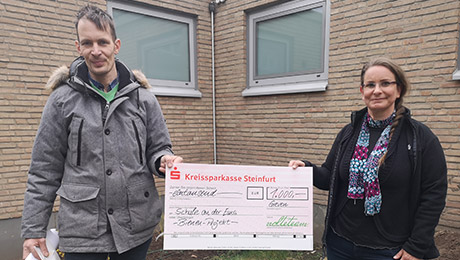 Das nolteteam unterstützt das Projekt mit 1.000 Euro Zwei Personen mit übergroßem Scheck in der Mitte