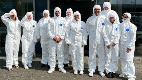 10 Personen in weißen Einwegschutzanzügen