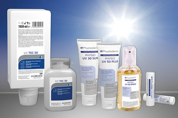 Verschiedene Tuben, Flaschen und Lippenstifte mit UV-Schutzprodukten für den gewerblichen Hautschutz, dahinter gleißende Sonne