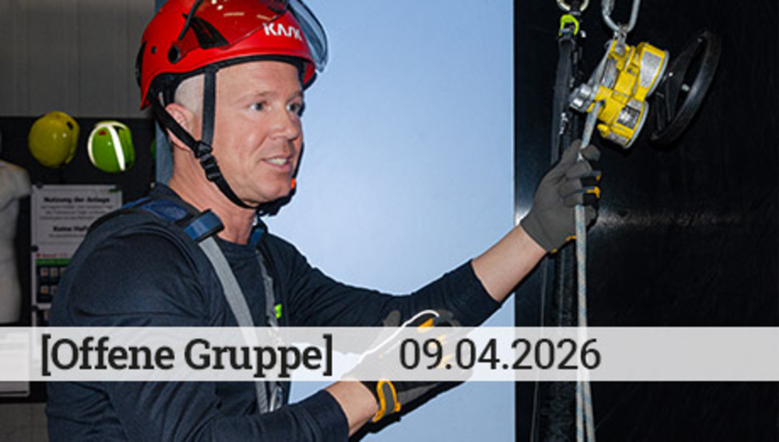 Ein Mann mit einem roten Helm hält eine Handkurbel