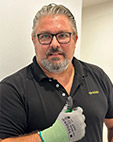 Brustportrait eines Mannes, der eine mit einem Handschuh bekleidete Hand in der "Daumen-hoch"Geste hält